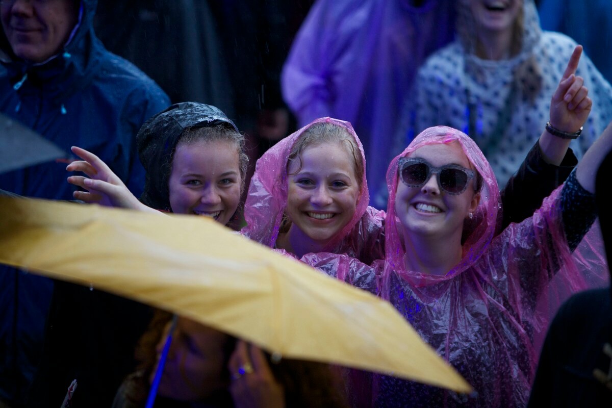 Ondanks de felle regen blijven lachen. Foto: Ton van den Berg